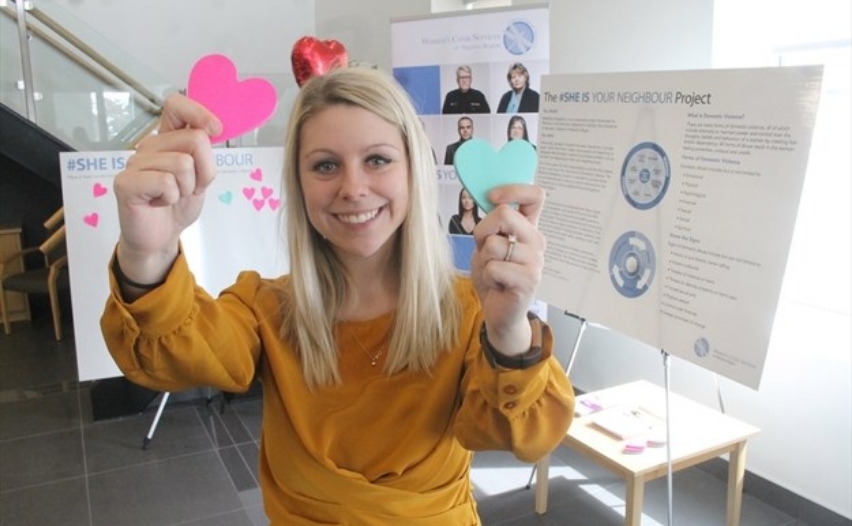 Woman holding 2 cardboard hearts